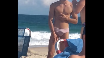 Gay excitado na praia roçando